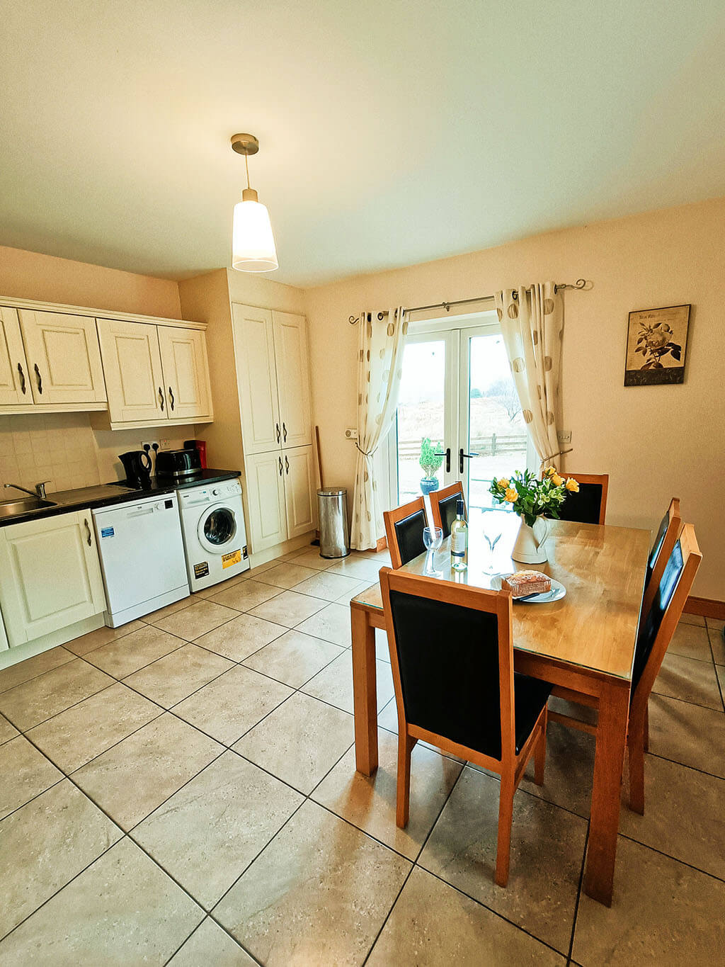 kitchen-double-door-table-chairs-wine-cake-glasses-washing-machine-dishwasher-cupboards-tiles-donegal-ireland