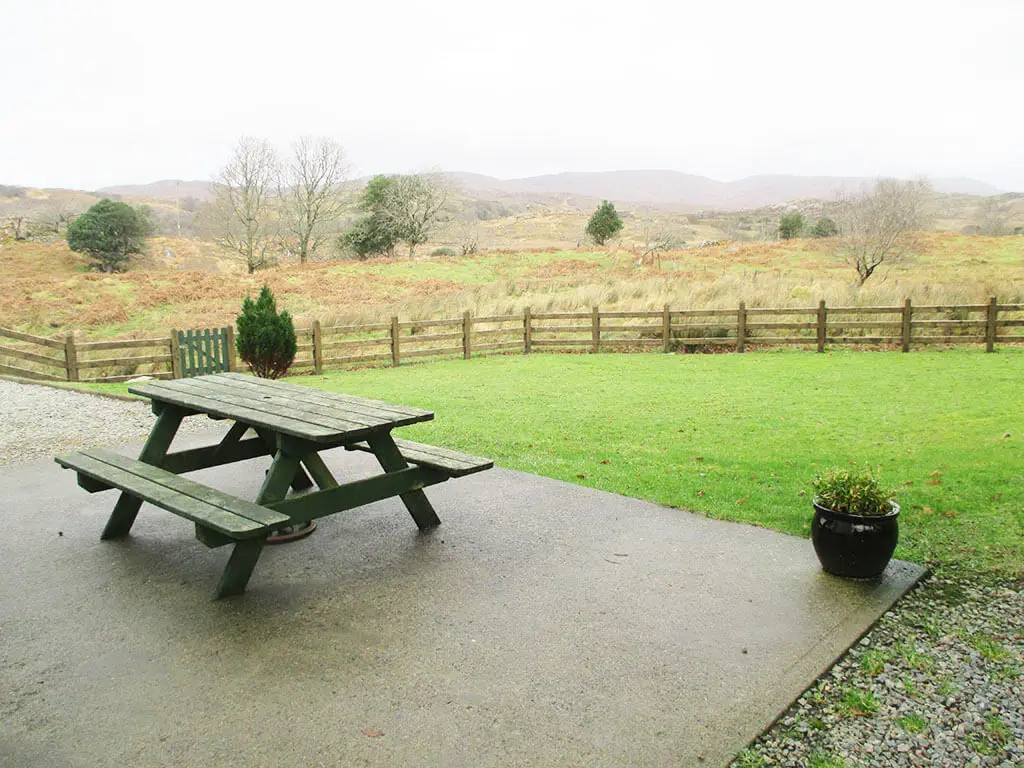 seating-area-outdoors-cottage-donegal-ireland-vacation-rental-holiday-bench-grass-fence-table